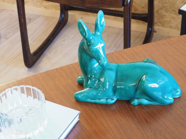Biche couchée en céramique craquelée.