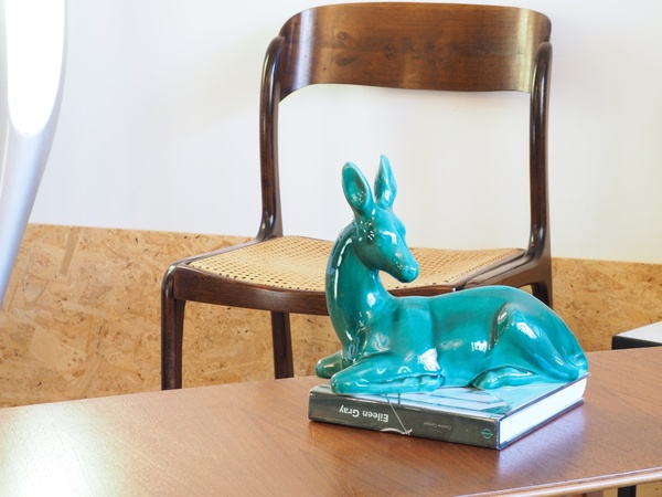 Biche couchée en céramique craquelée.