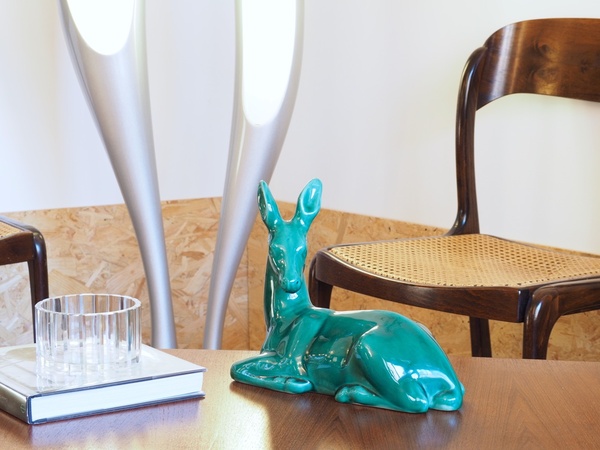 Biche couchée en céramique craquelée.