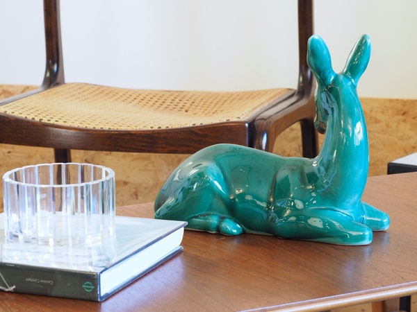 Biche couchée en céramique craquelée.